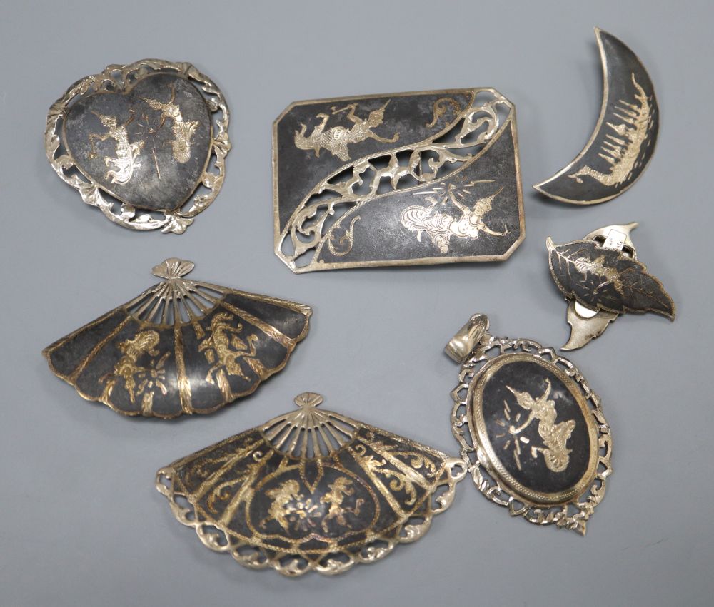 Five assorted Thai sterling and niello brooches, a pair of similar ear clips and a pendant.